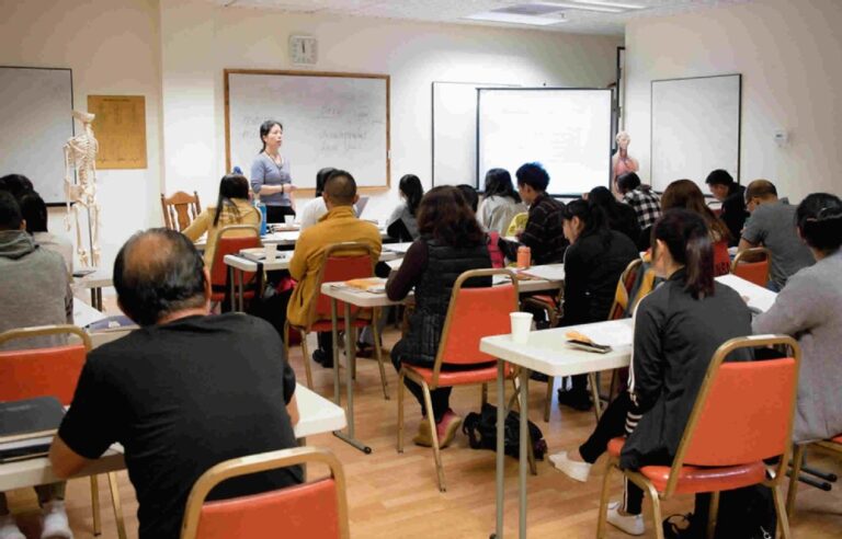 students in desks, listening to lecture