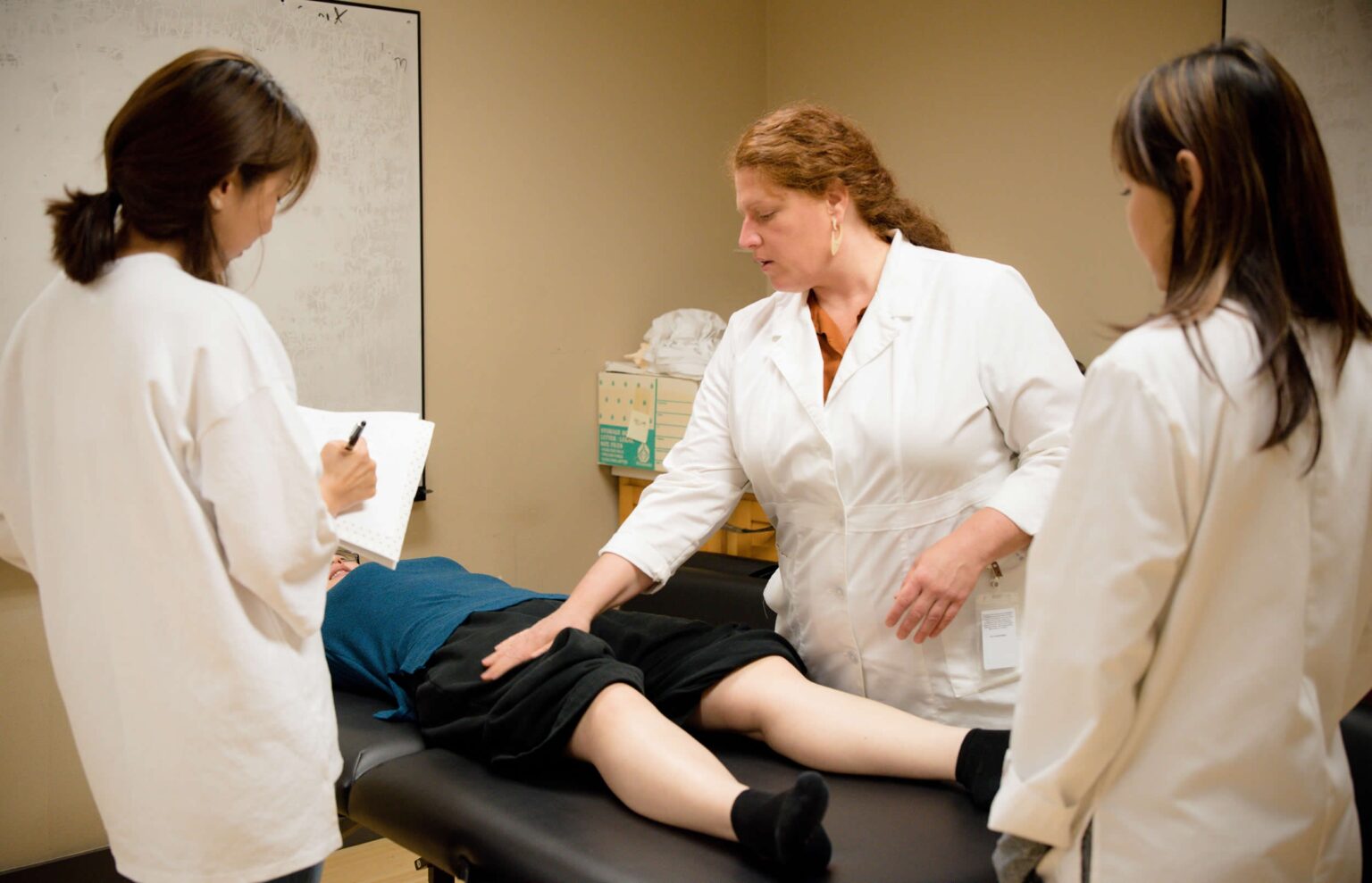 students learning acupuncture with patient