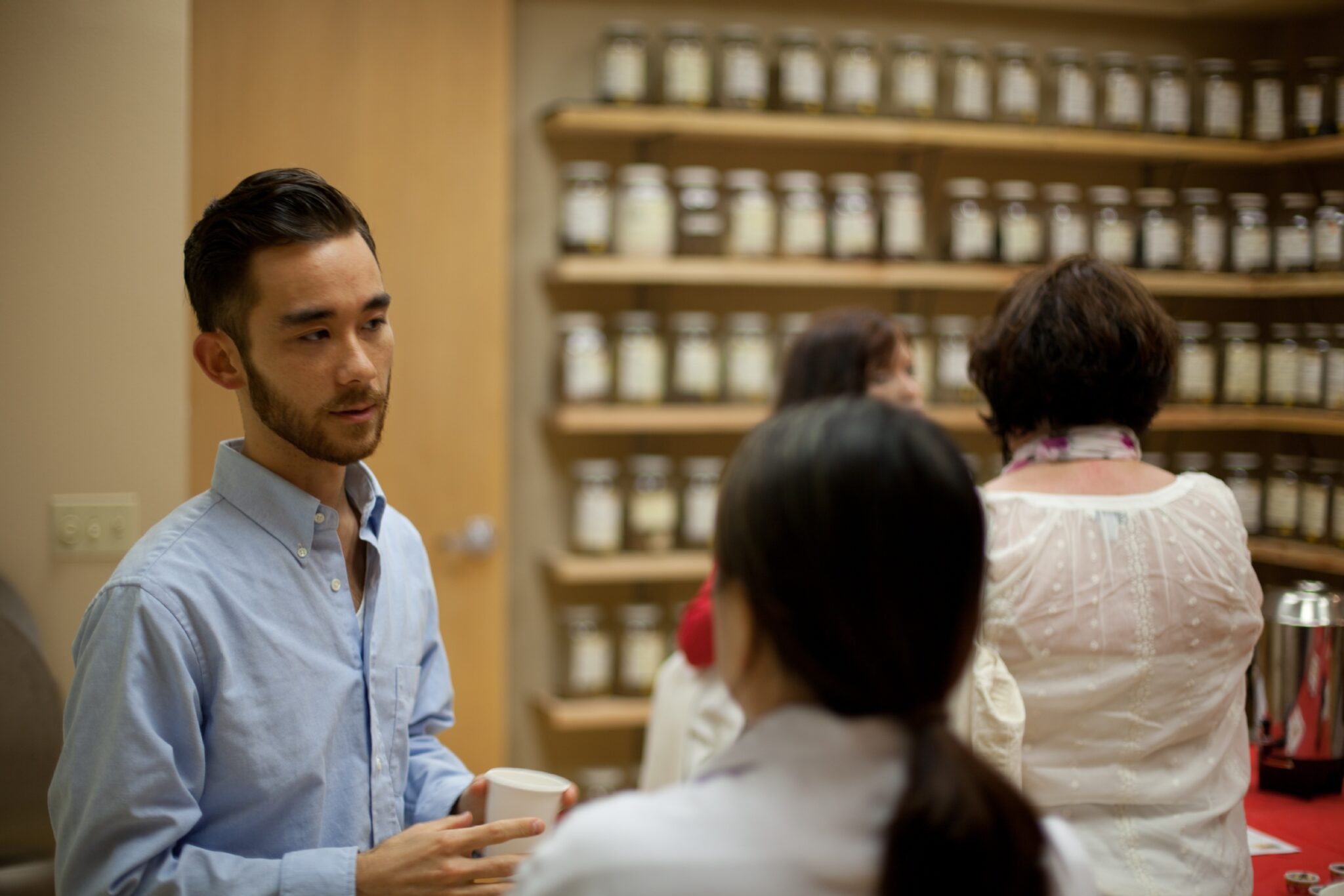 man and woman talking in front of herb shelf at acchs clinic