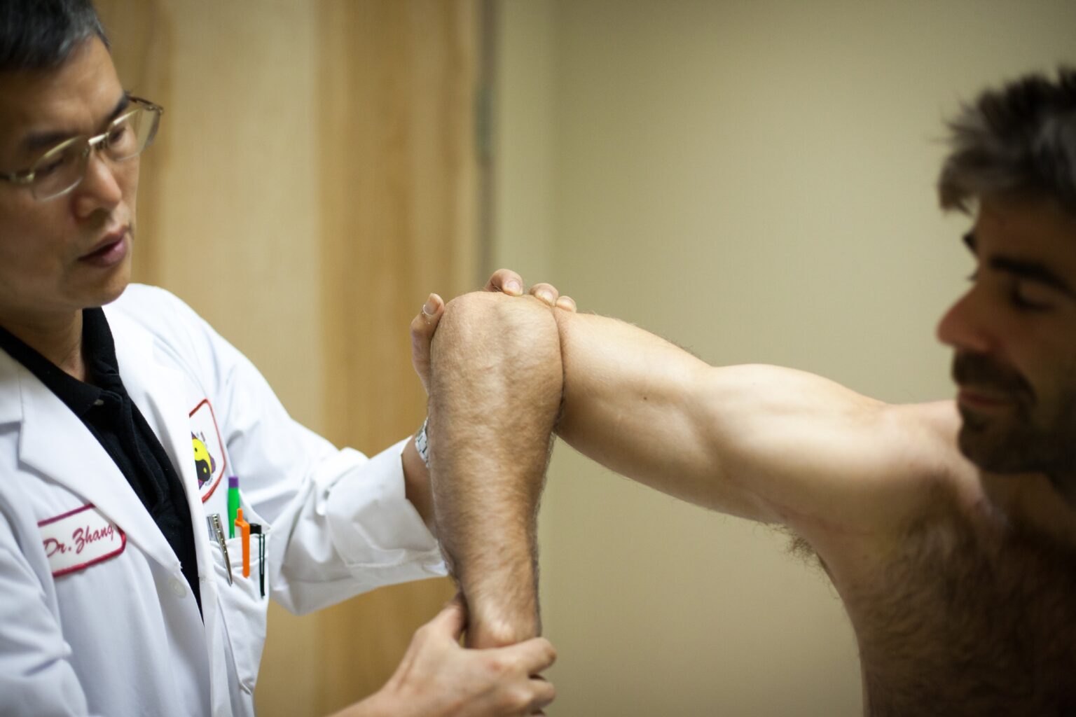 practitioner manipulating a patient's elbow