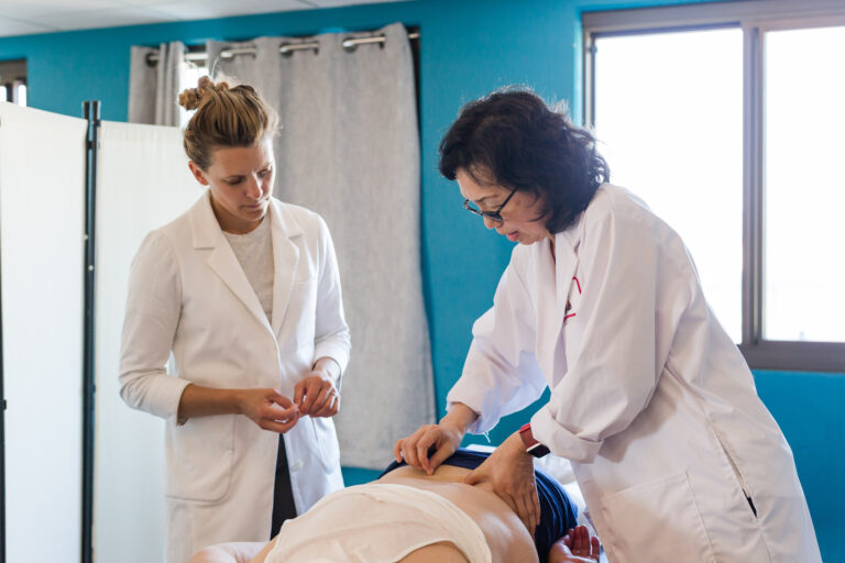 student acupuncturists learning form teacher at clinic