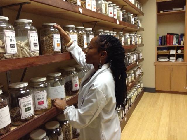 woman getting herbs from herb room at acchs